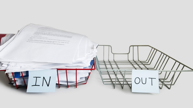 Comment externaliser avec succès les tâches de son entreprise ? Panier plein de documents à côté d'un panier vide