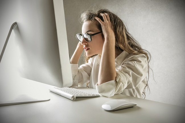 Jeune fille perplexe devant un ordinateur